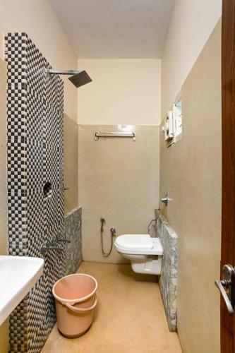 a bathroom with a toilet and a sink and a shower at RAGAM RESORT in Alleppey