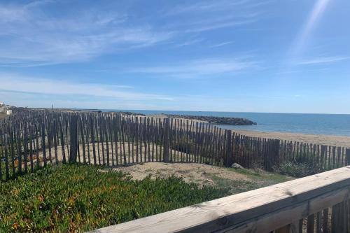 a wooden fence on a beach with the ocean at Maisonette by the sea in Frontignan