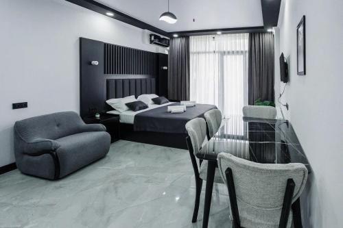 a bedroom with a bed and a table and chairs at Апарт-отель Homeland in Gonio