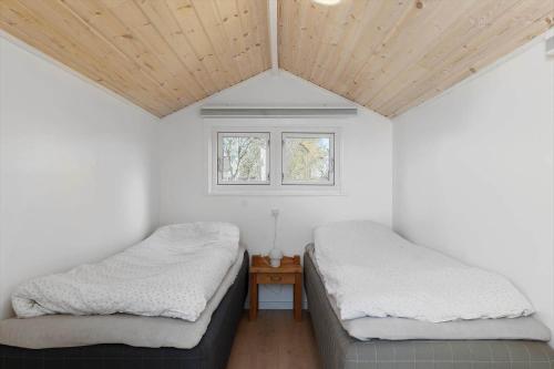 two beds in a room with a wooden ceiling at OH585-Hadsund-Brondbaekken-34 in Øster Hurup
