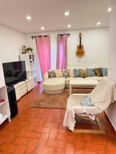 a living room with a couch and a tv at The room in Odivelas