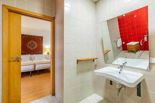 a bathroom with a sink and a mirror at HI Tavira – Pousada de Juventude in Tavira