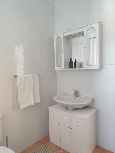 a white bathroom with a sink and a mirror at Alojamento Local Velas Balcony in Velas