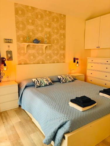 a bedroom with a bed with a blue comforter at Sardegna selvaggia a due passi dal mare in Vignola Mare