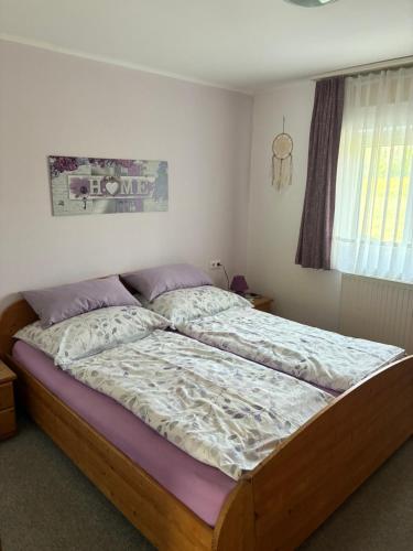 a bedroom with a large bed with purple sheets at Pension Hutterer in Scharnstein