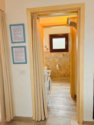 a bathroom with a white toilet in a hallway at Sardegna selvaggia a due passi dal mare in Vignola Mare