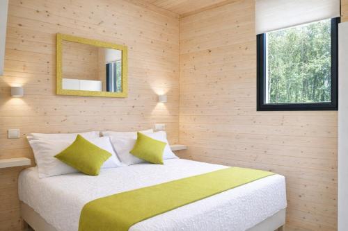 a bedroom with a bed with a mirror on the wall at Cabañas Compostela - Cabaña Bosque Encantado in Santiago de Compostela