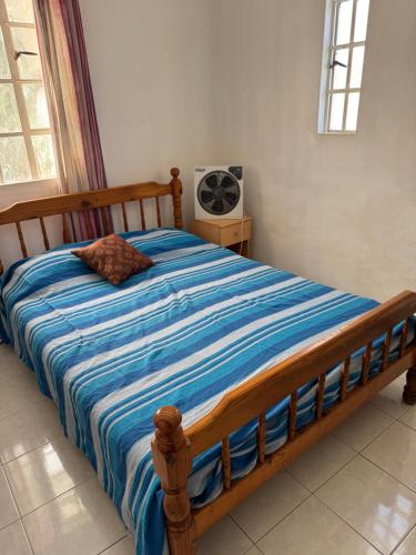 a bedroom with a wooden bed with a blue comforter at Coco villa in Flic-en-Flac
