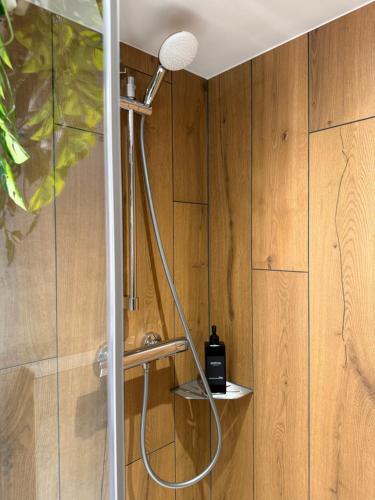 a shower in a bathroom with wooden walls at S'Nekel Hisel - Gîte à Offwiller in Offwiller
