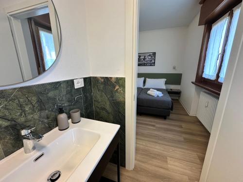 a bathroom with a sink and a mirror and a bed at B&B Piano B in Riva del Garda