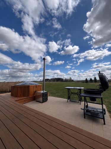 a wooden deck with a table and a grill at Lauga Puhkemaja in Tammeveski