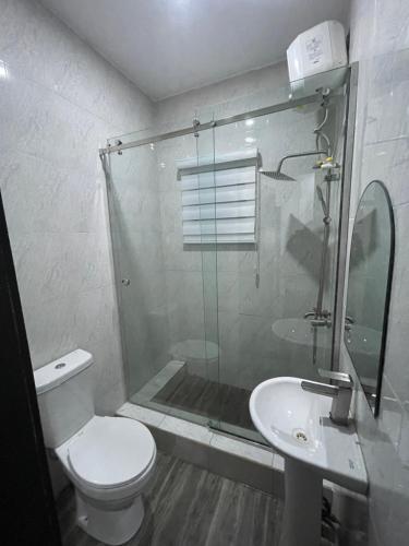 a bathroom with a shower and a toilet and a sink at Kennys place in Isaga-Abosule
