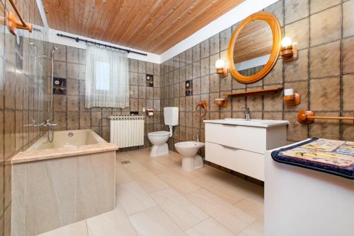 a bathroom with a tub and a toilet and a sink at Enjoy & Relax Da Elvia in Rovinj