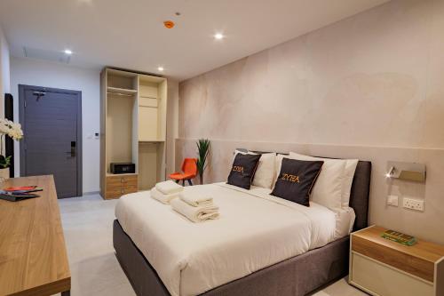 a bedroom with a large bed and a orange chair at Zyra Hotel St Julians - Adults only in St. Julianʼs