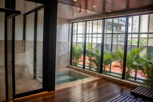 an indoor pool in a room with large windows at Opus Gyro Vaca Brava Studio Luxo e Aconchego in Goiânia