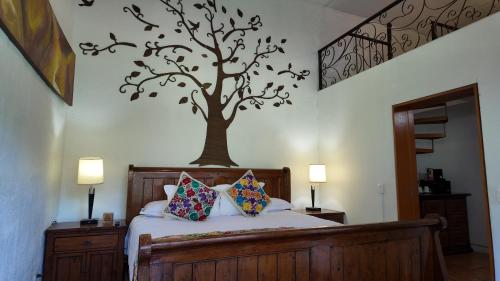 a bedroom with a tree mural on the wall at Hacienda del Lago Boutique Hotel in Ajijic