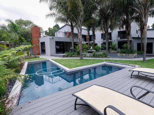 an outdoor deck with a swimming pool and a house at Pitzer Suites in Midrand