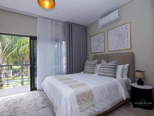 a bedroom with a bed and a large window at Pitzer Suites in Midrand