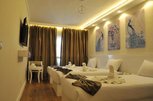 ein Hotelzimmer mit drei Betten und einem Fenster in der Unterkunft Salma Hotel in Kairo