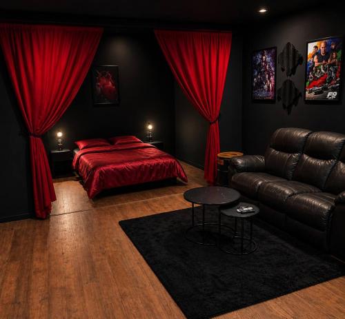 a bedroom with a bed and a leather couch at Appartement thème cinéma in Cazouls-lès-Béziers