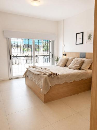 a white bedroom with a large bed and a window at Lezama Park in Buenos Aires
