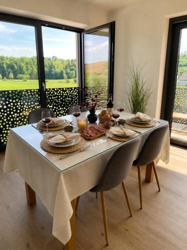 a dining room table with a white tablecloth and wine glasses at Romantic Sunset Retread I 4 Min to A2 I E-Bikes I Near Ljubljana in Velika Loka