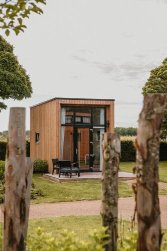 a small building with a bench in front of it at Tiny House in Kesteren