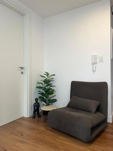 a living room with a couch and a potted plant at Just 100 meters from Shopping del Sol in Asunción