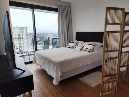 a bedroom with a bed and a large window at Just 100 meters from Shopping del Sol in Asunción
