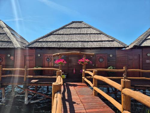 a building with a wooden bridge with flowers on it at Domček na vode 5 in Senec