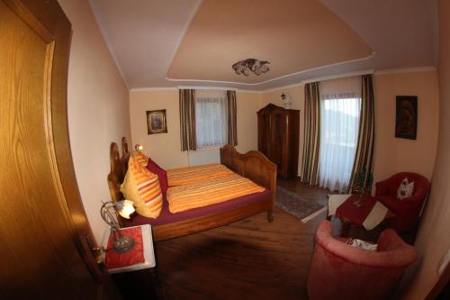 a bedroom with a bed and two chairs in a room at Oberharreithhof in Sankt Martin am Tennengebirge