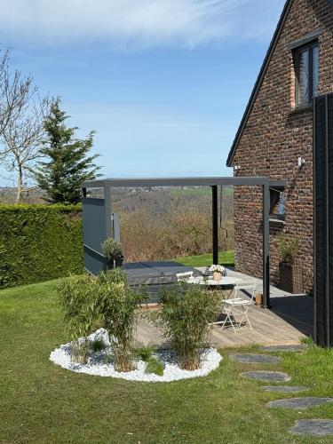a house with a patio with a table in the yard at Beach House in Ardennes in Chaudfontaine