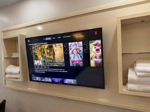 a flat screen tv on a wall in a bathroom at lily airport otel in Arnavutköy
