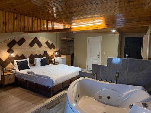 a bedroom with a bed and a bath tub at lily airport otel in Arnavutköy