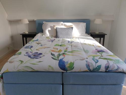 a bedroom with a blue bed with a floral bedspread at Guesthouse 10 in Schellinkhout