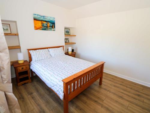 a bedroom with a bed with a wooden bed frame at Cahir Cottage in Ballinrobe