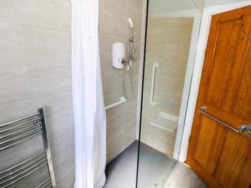 a bathroom with a shower with a glass door at Cahir Cottage in Ballinrobe