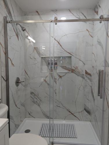 a shower with a glass door in a bathroom at Fresh start small breakfast cook and serve your self in Lubbock