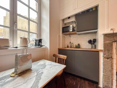 a kitchen with a table and a counter top at Petit Cocon Intra-muros in Saint Malo