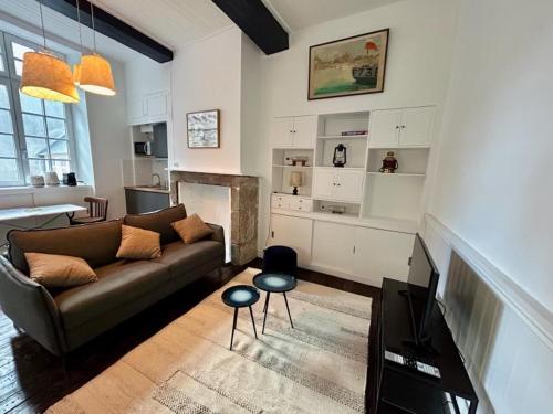 a living room with a couch and a kitchen at Petit Cocon Intra-muros in Saint Malo