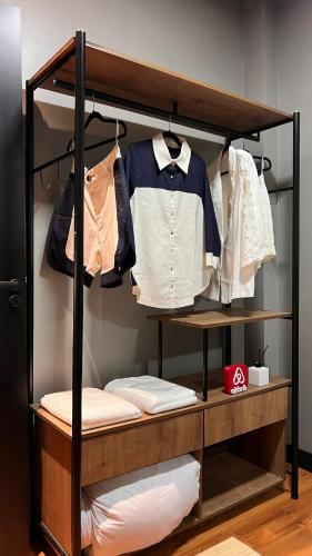 a closet with a rack with shirts and clothes at Sobrado inteligente, A C, TVs Smart e garagem in Toledo