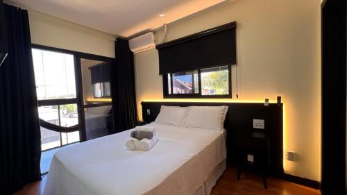 a bedroom with a white bed with two pillows on it at Sobrado inteligente, A C, TVs Smart e garagem in Toledo