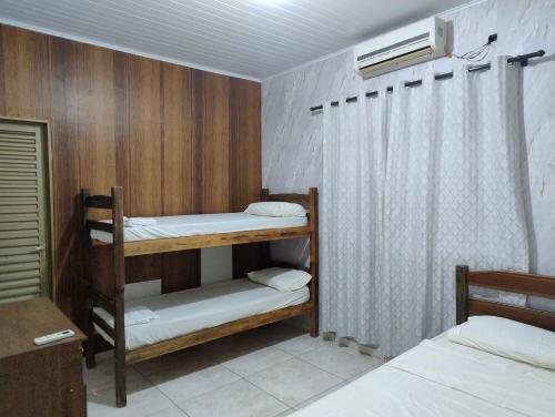 a room with two bunk beds and a window at Pesqueiro Rancho dos Reis in Aquidavana