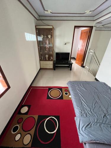 a living room with a bed and a red carpet at Widodaren Homestay in Probolinggo