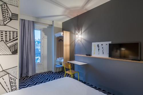 um quarto de hotel com uma cama, uma secretária e uma televisão em Ibis Styles Paris Place d'Italie - Butte Aux Cailles em Paris
