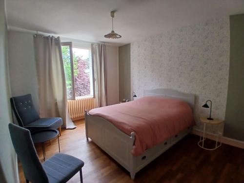 a bedroom with a bed and a chair and a window at Maison Angers bord de loire, rue Jules Quelin in Les Ponts-de-Cé