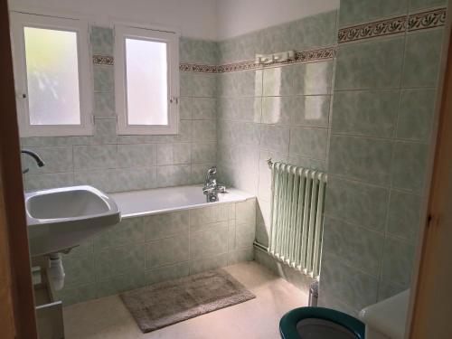 a bathroom with a tub and a sink and a window at Maison Angers bord de loire, rue Jules Quelin in Les Ponts-de-Cé