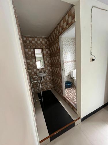 a small bathroom with a mirror and a toilet at Widodaren Homestay in Probolinggo