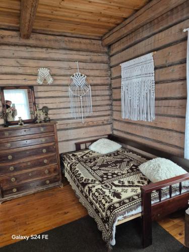 a bedroom with a bed in a wooden cabin at Erämökki Puruveden rannalla in Vaara