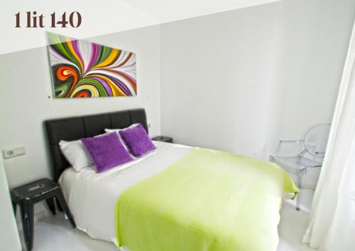 a bedroom with a bed with purple and green pillows at Apt 5 Eaux-Chaudes proche Laruns et Espagne in Laruns